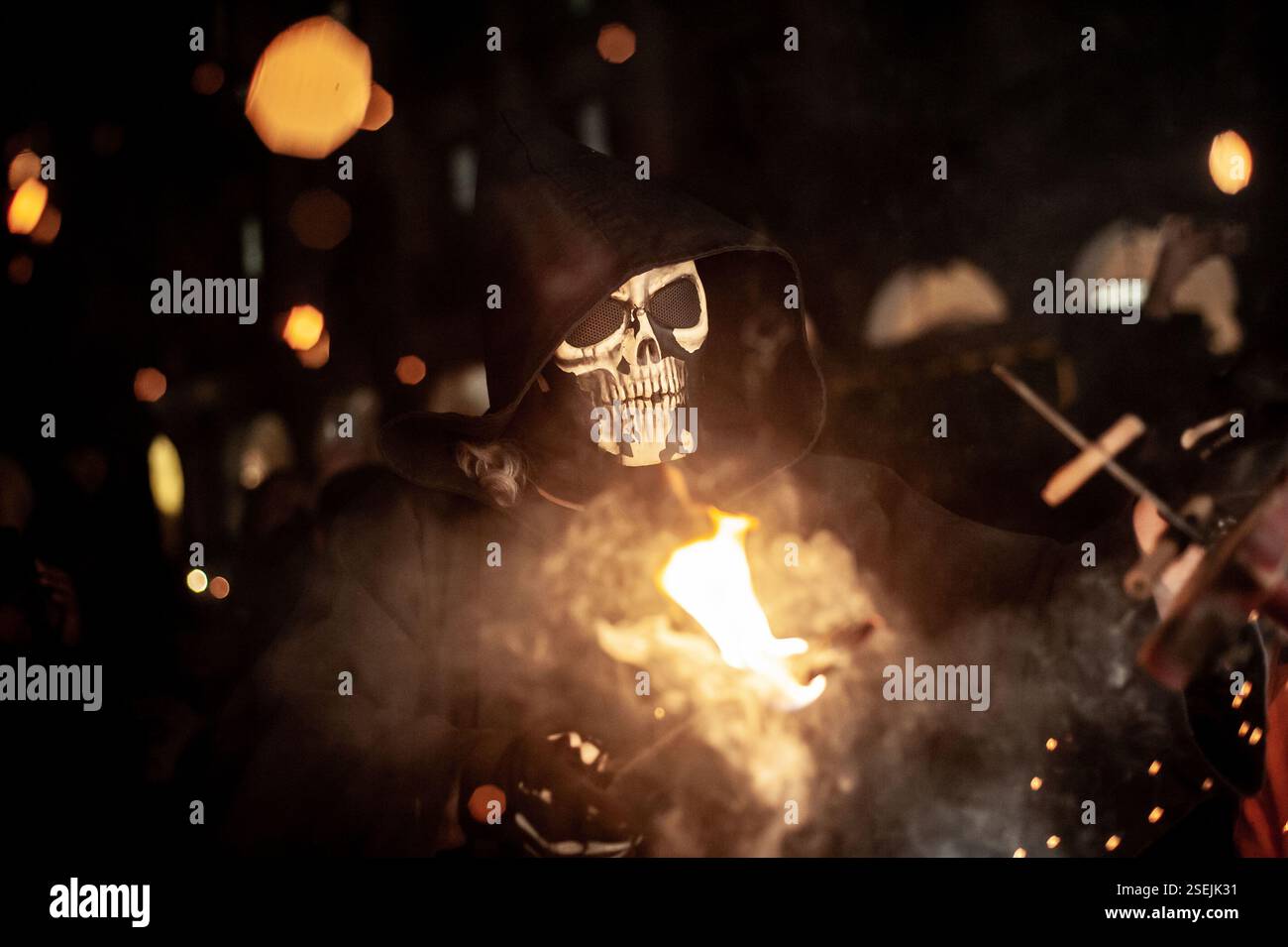 Barcelona, Spanien. Februar 2025. Barcelona, Spanien: Ein Teufel mit Skelett-Maske zündet bei einem Korrefoc anlässlich des Santa Eulalia Winterfestivals in Barcelona ein Feuerwerk an. Correfocs sind eine alte katalanische Tradition, in der sich die Menschen als Teufel kleiden und Feuerwerkskörper und Fackeln anfeuern. Quelle: Jordi Boixareu/Alamy Live News Stockfoto