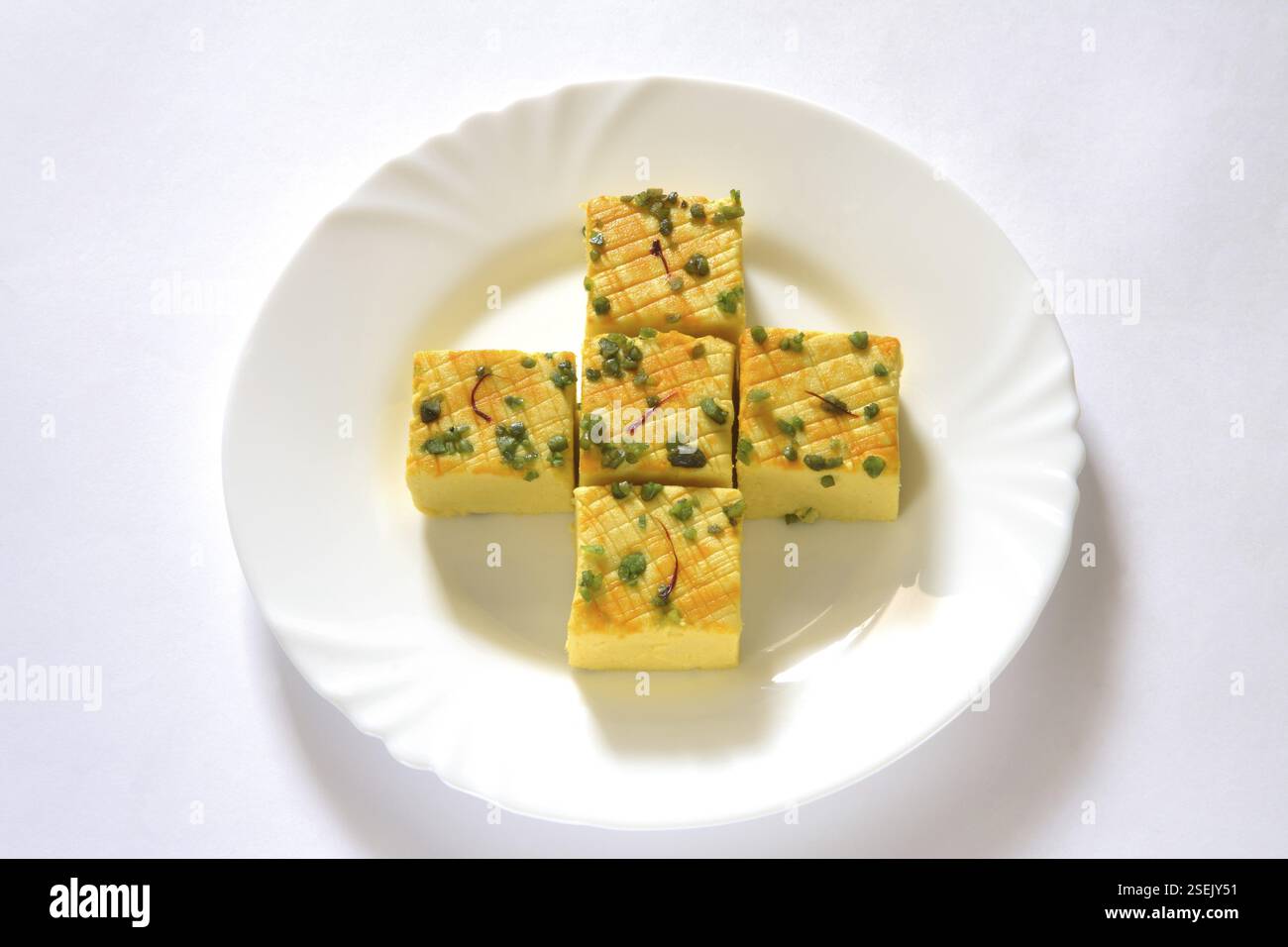 Indische süße Sandesh-bengalische Mithai-Garnitur mit Pistazien und Safran, serviert auf Teller Stockfoto