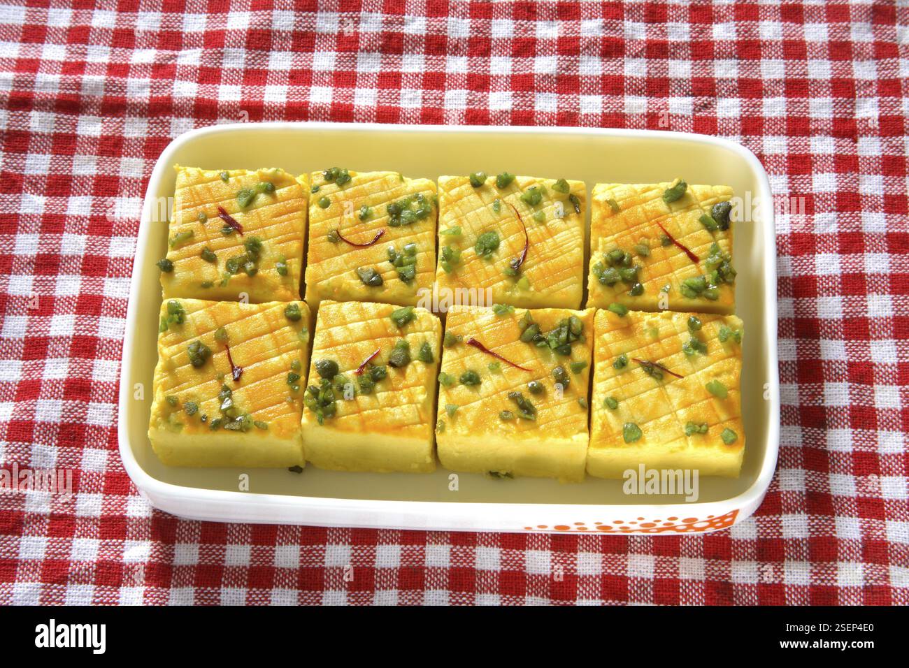 Indische süße Sandesh-bengali-Mithai-Garnitur mit Pistazien und Safran, serviert im Behälter auf Tuch Stockfoto