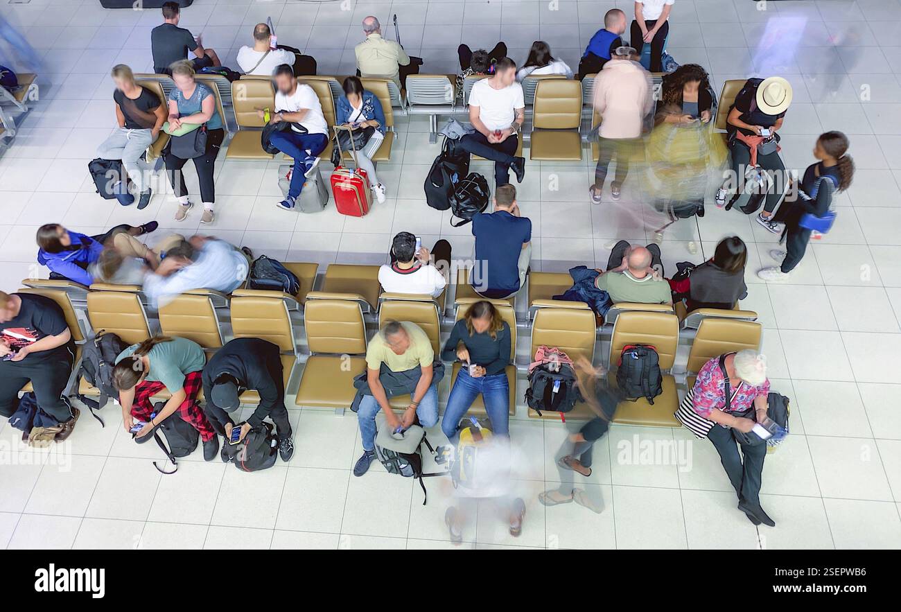 Touristen, die in der Check-in-Halle auf ihren Flug warten, verschwommene Sicht auf sich bewegende Personen Stockfoto
