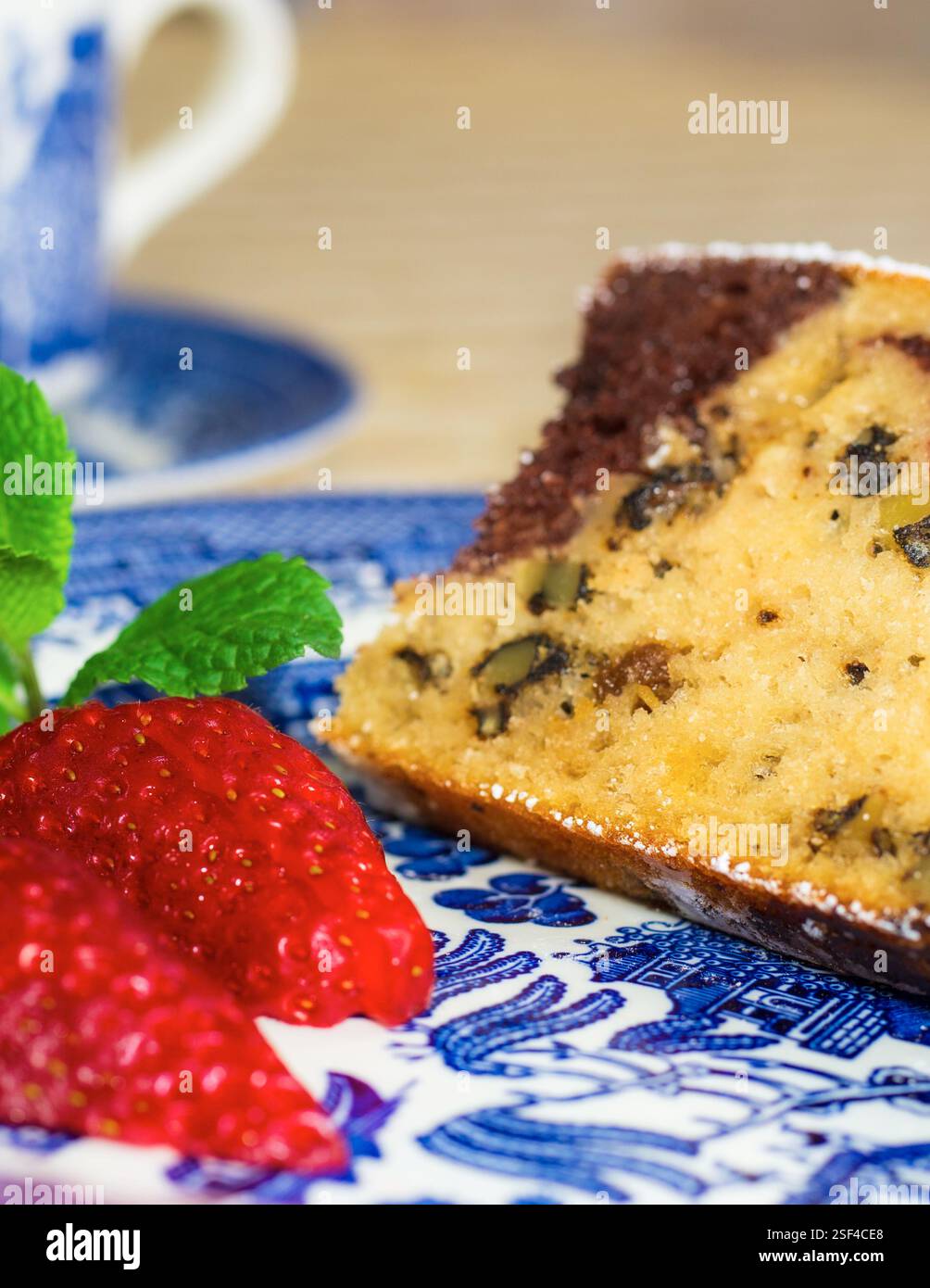 Marmorkuchen mit Rosinen und Walnüssen. Ein Stück Kuchen auf einem Teller mit einer Erdbeere. Stockfoto