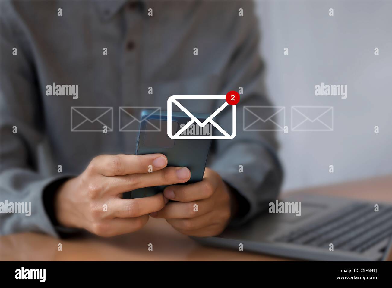 Man verwendet ein Smartphone mit einem Symbol, das 2 neue E-Mail-Nachrichten benachrichtigt. Kommunikationstechnologie für Unternehmen. Stockfoto
