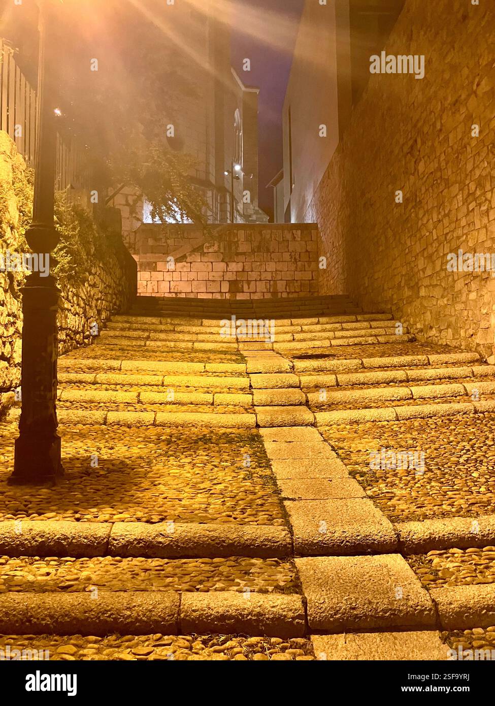 Kopfsteinpflastertreppen in einer ruhigen Straße in einer spanischen Stadt bei Nacht. - Smartphone-aufgenommenes Stockfoto