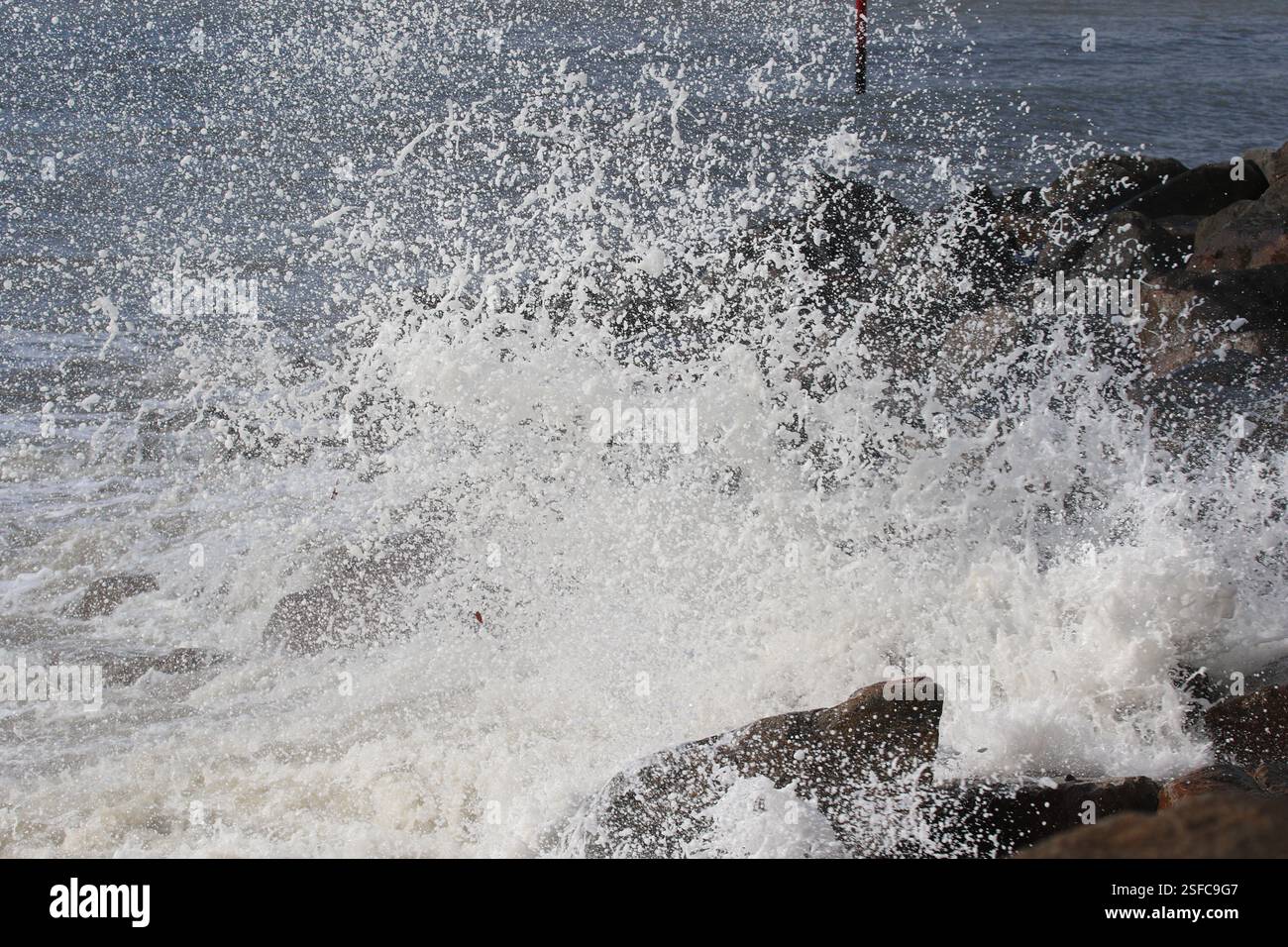 Große Wellen krachen und plätschern gegen die Felsen. Stockfoto