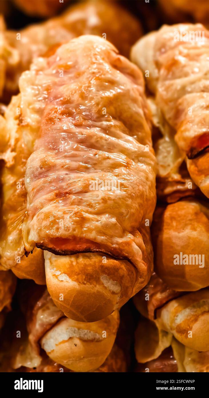 Eine wunderbare Vorspeise in Form eines Baguettes mit Speck und Käsescheiben, die im Ofen oder in der Mikrowelle gebacken werden. Stockfoto