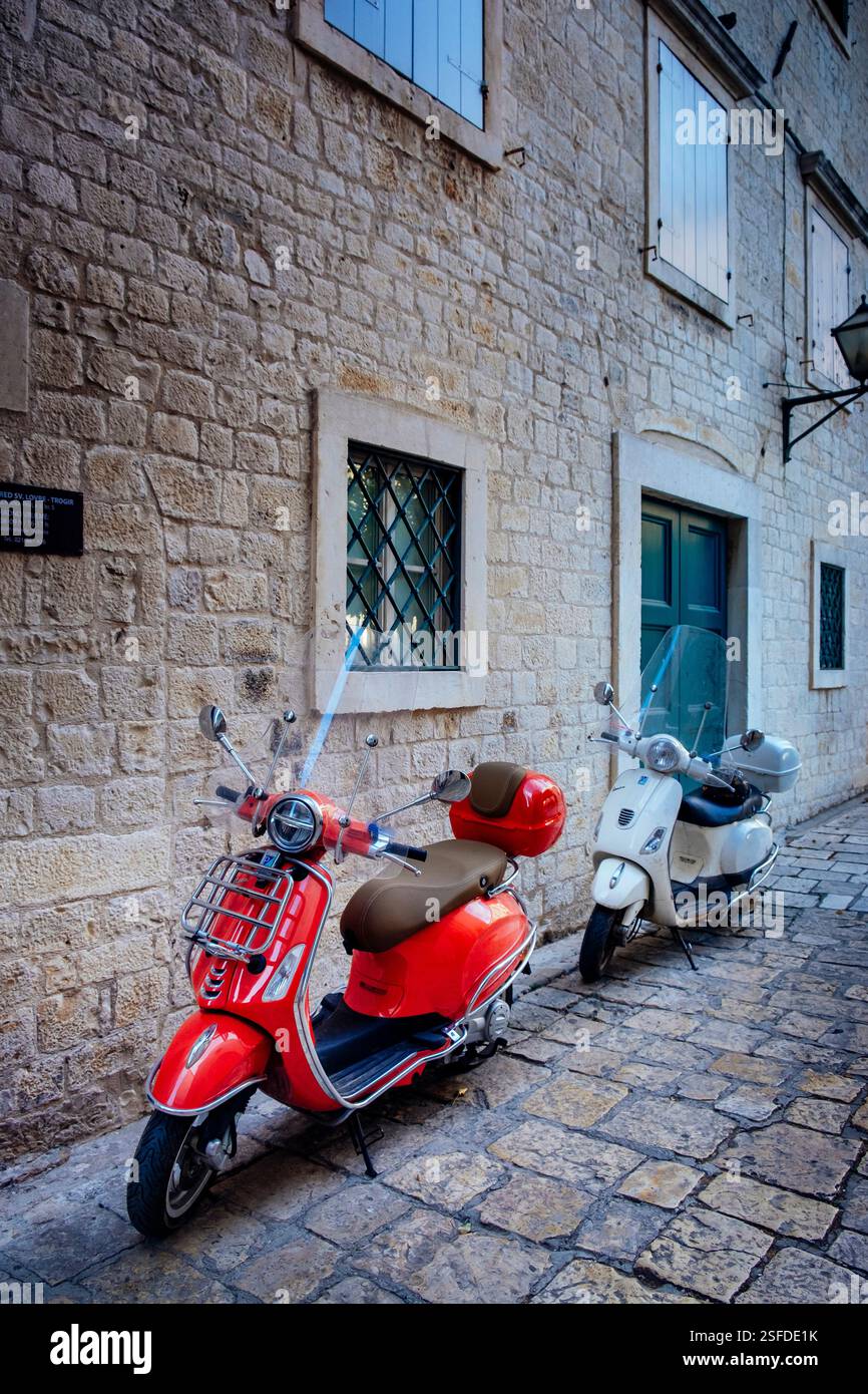 Rote und weiße Roller, roter Piaggio Roller, Kopfsteinpflasterstraße, Trogir, Kroatien Stockfoto