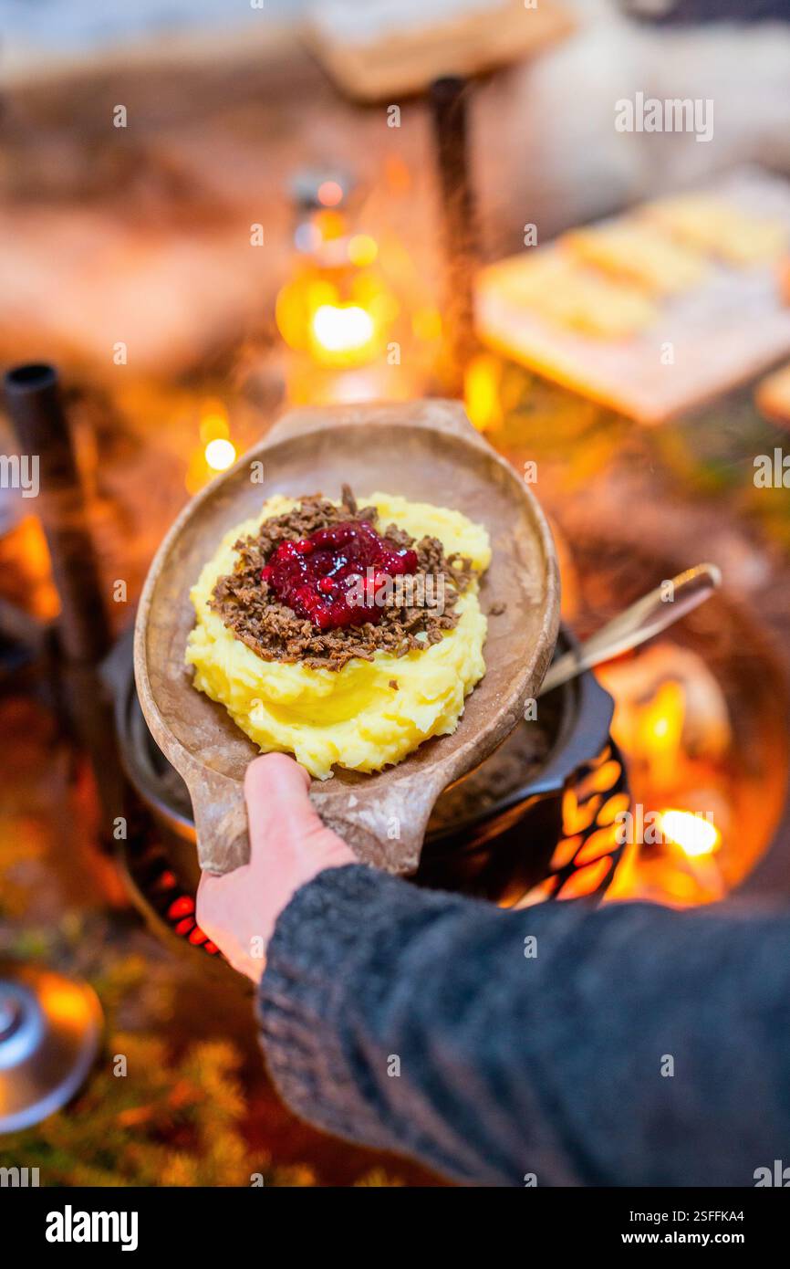 Ein traditionelles finnisches Gericht, Poronkäristys (sautiertes Rentier), serviert auf einem Holzteller mit cremigem Kartoffelpüree und einem Topping Preiselbeersauce Stockfoto