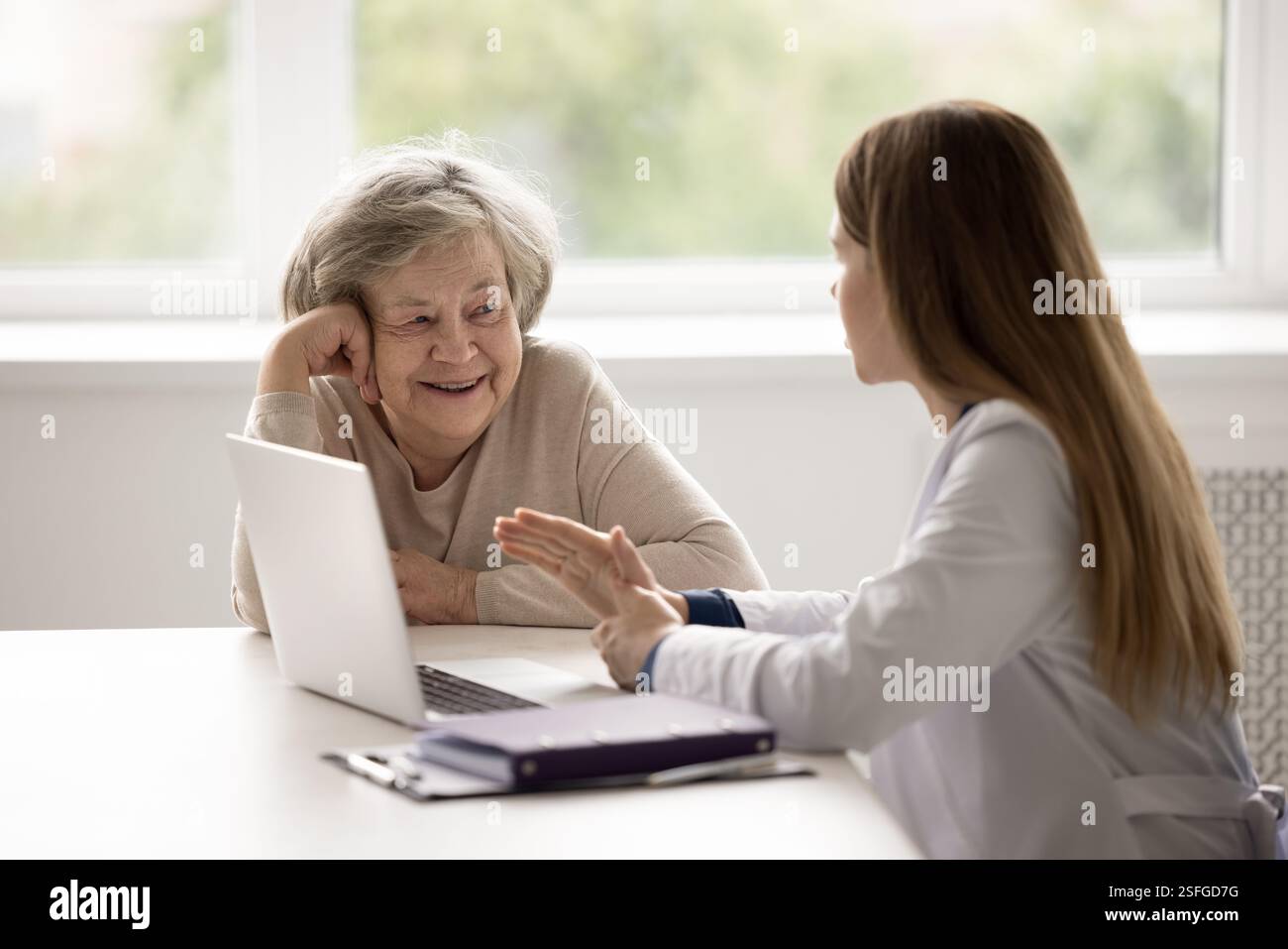 Lächelnde Großmutter im Alter mit vertrauenswürdigem Arzt Stockfoto
