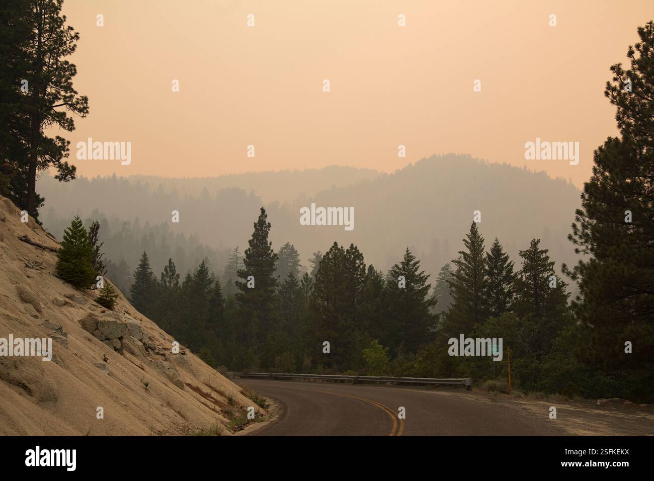 Janesville Grade im Lassen County, Kalifornien, bedeckt mit dickem Rauch des Dixie-Feuers von 2021, mit trüben bewaldeten Bergen im Hintergrund. Stockfoto