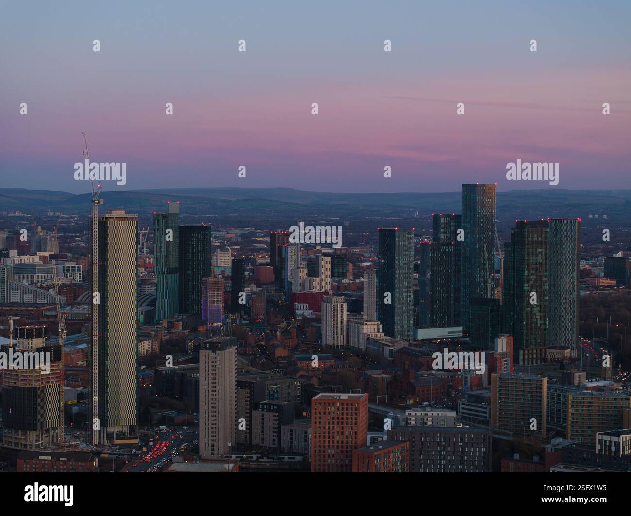 Ein lebhafter Blick in die Abenddämmerung auf die Skyline von Manchester mit den legendären modernen Wolkenkratzern von Deansgate und einem ruhigen, pastellfarbenen Himmel, der die städtische Schönheit unterstreicht Stockfoto