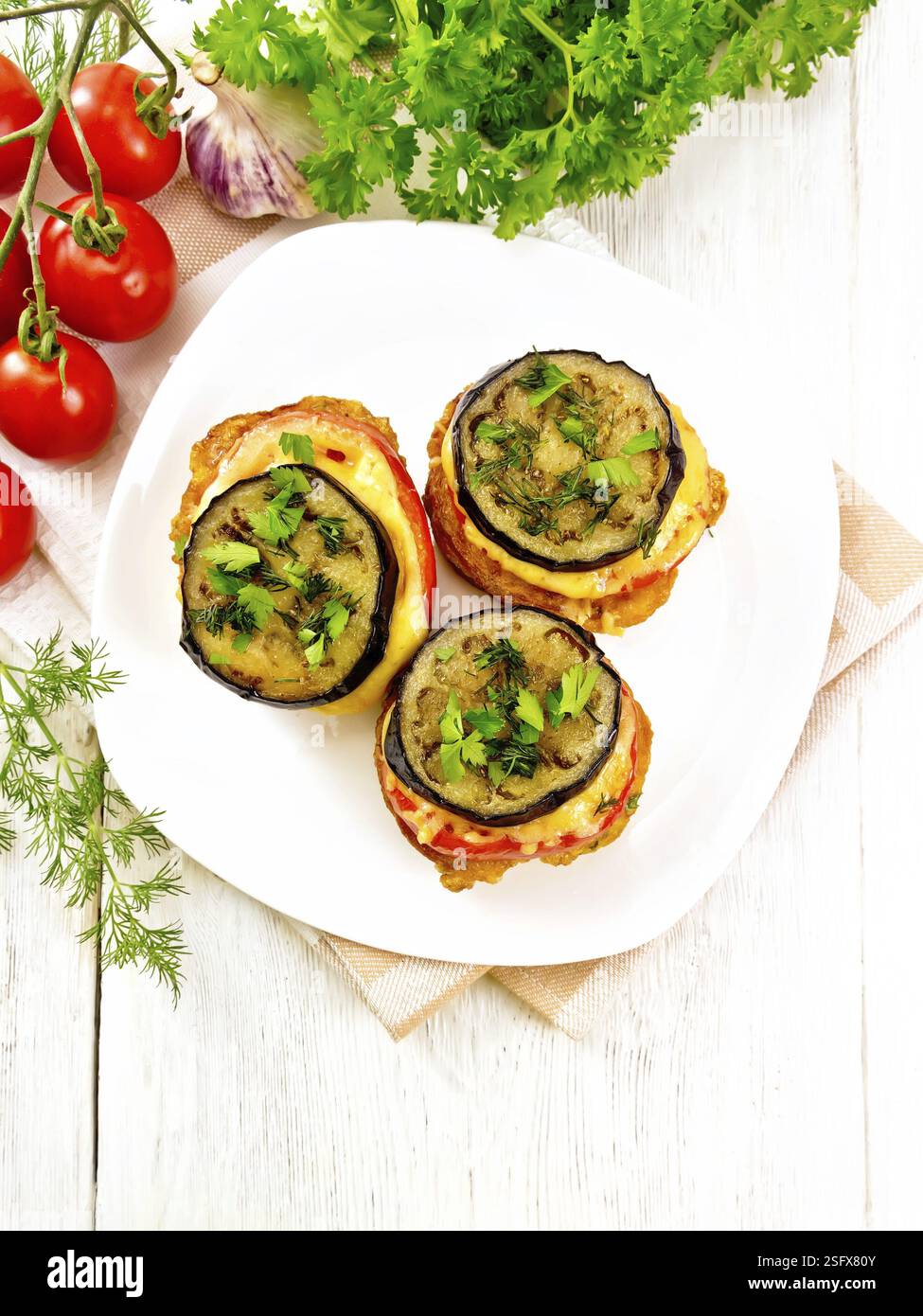 Mit Ei, Tomate, Käse und Auberginen Scheiben Brot toasten, bestreut mit Dill und Petersilie in eine weiße Platte auf Serviette auf Holzbrett top backgrou Stockfoto