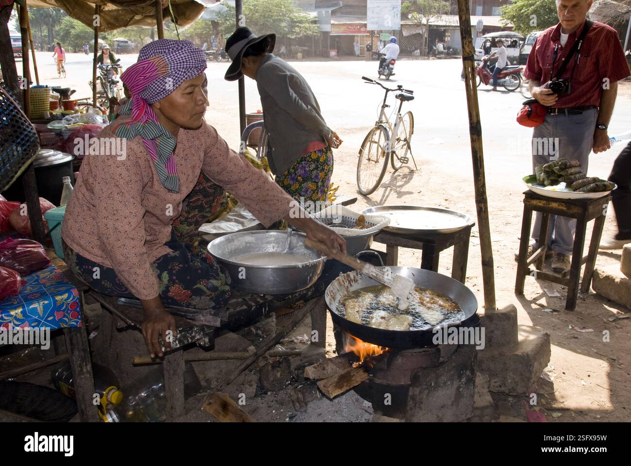 Frau frittiert Fisch am Straßenmarkt in der Nähe des Tonle SAP Lake. Stockfoto