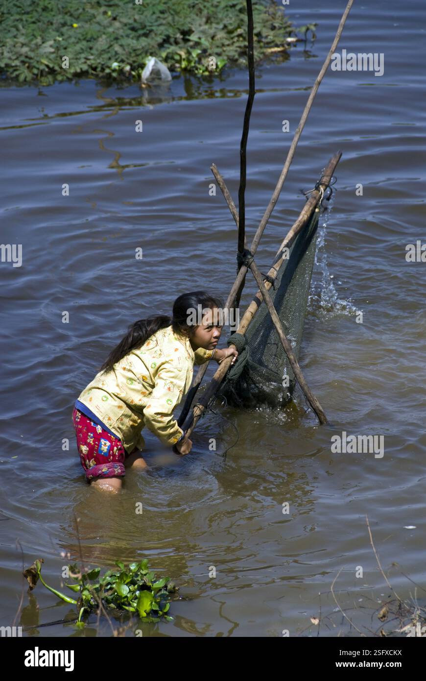 Das junge Mädchen arbeitet mit Fischernetzen in Tonle SAP Lake, nahe Siem Reap. Stockfoto