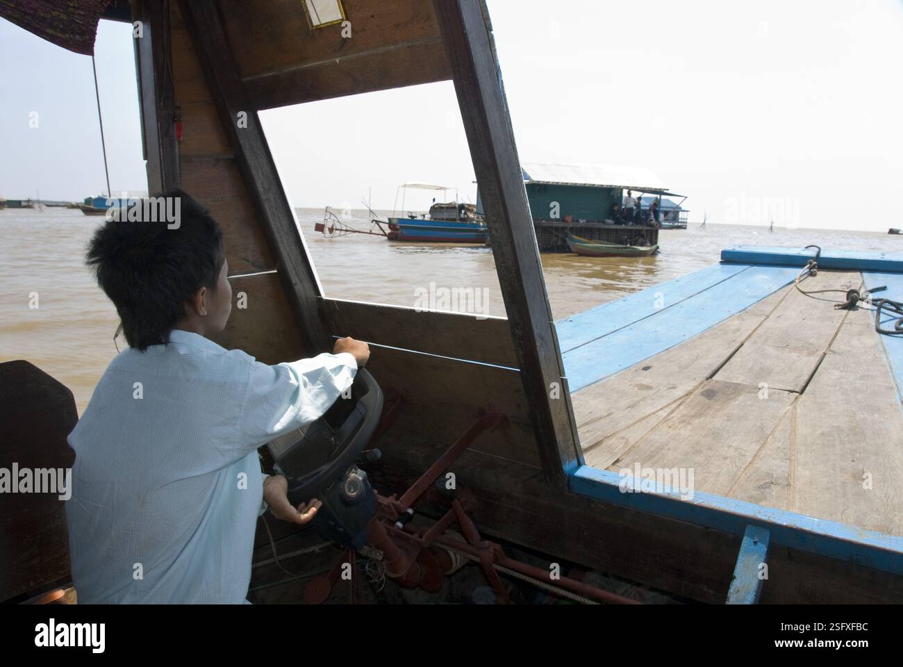 Ein kleiner Junge fährt ein Boot, das Touristen zum Tonle SAP Lake bringt. Stockfoto