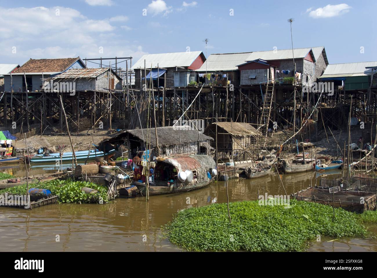 Fischerboote liegen im Fluss neben Häusern auf Stelzen am Tonle SAP Lake nahe Siem Reap, Kambodscha. Stockfoto