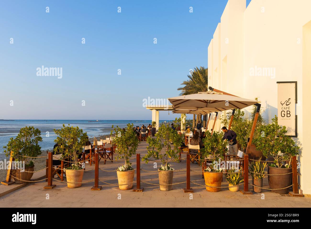 Die Leute genießen einen ruhigen Nachmittag im Café des Bahrain Fort Museum am Karabababad Beach in Manama, Bahrain Stockfoto