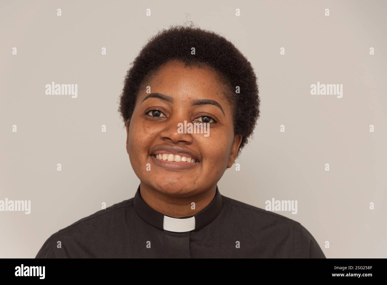 England Vereinigtes Königreich. 26.01.2025. Porträt einer Afrikanerin mit weißem kirchlichem Kragen und schwarzem Hemd. Stockfoto