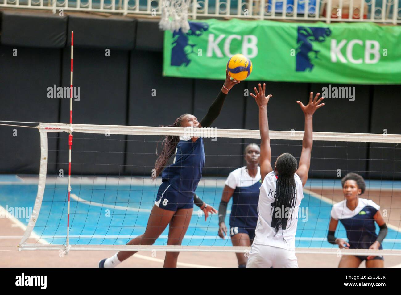 NAIROBI, KENIA - 7. FEBRUAR: KCB Sheilah Wabwile (links) spitzt gegen die Blockade der Kenia Defence Force Milkah Akinyi während des Kenia Cup Women Volleyb Stockfoto