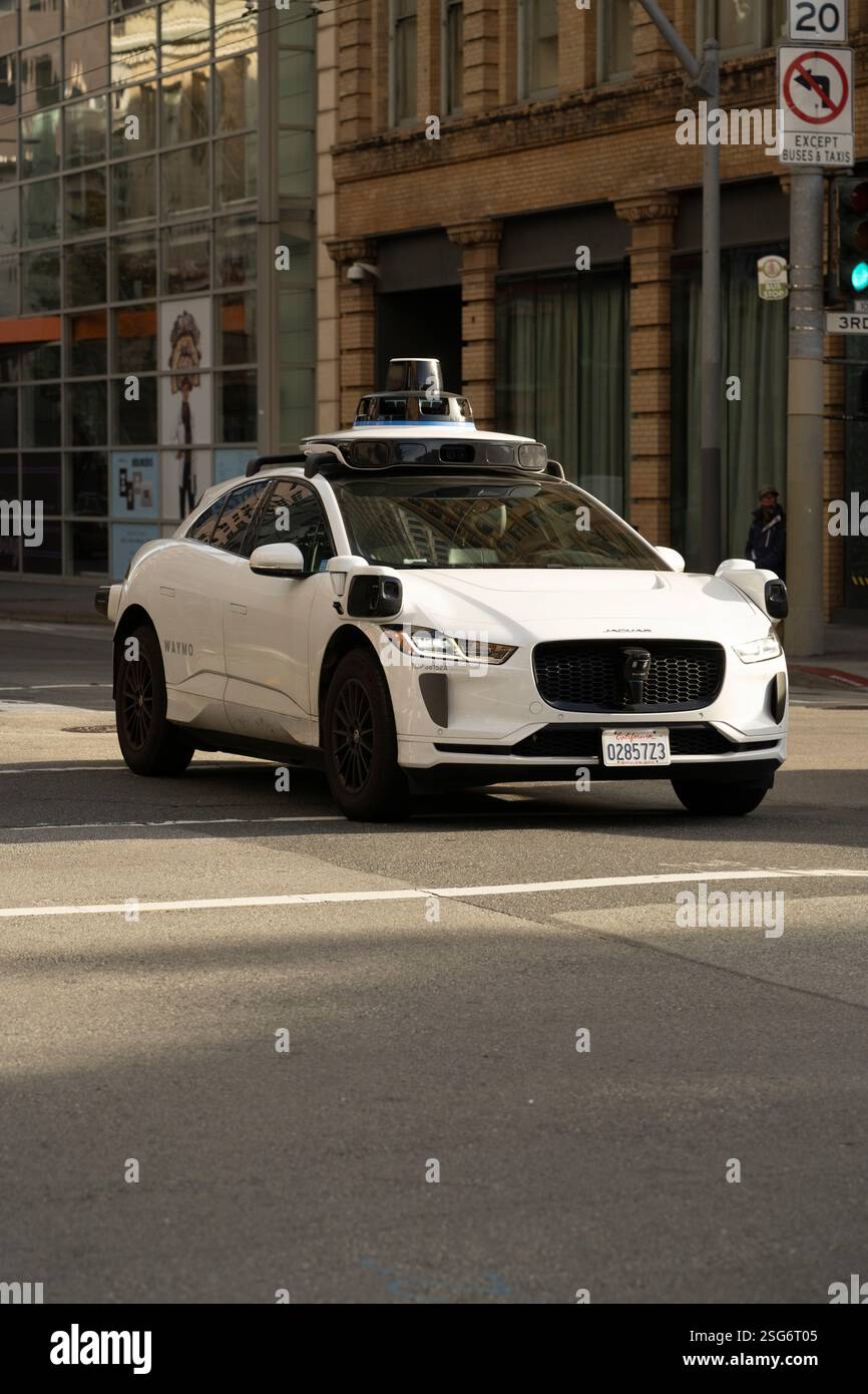 Waymo Auto (Jaguar I-Pace) überquert die 3rd Street in San Francisco. Autonome Fahrzeugtechnologie in Aktion. Stockfoto