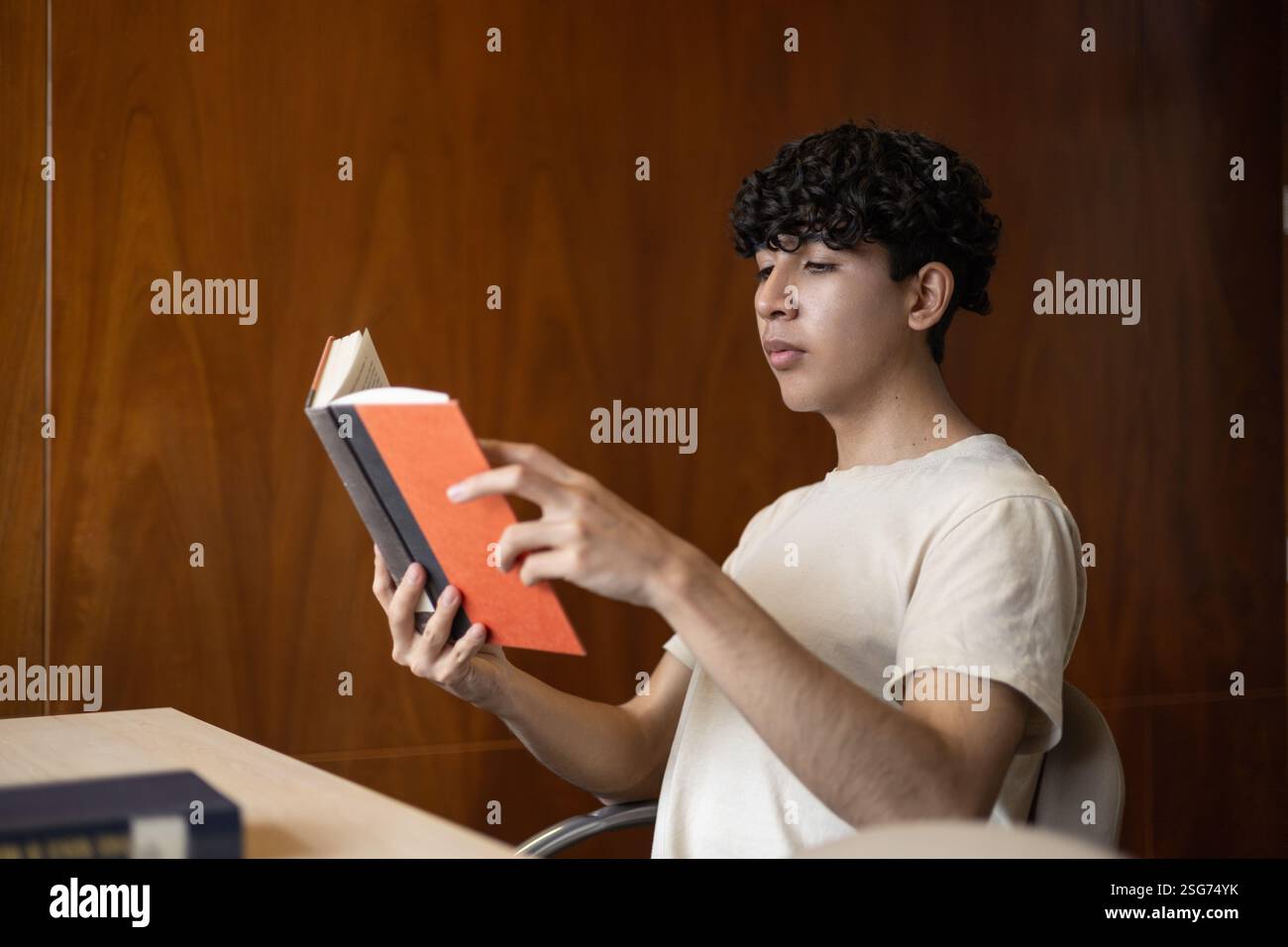 Eine Person, die sich tief konzentriert und versucht, ein Buch zu verstehen. Ideal für Themen wie Lernen, intellektuelles Wachstum, Konzentration und Lesen. Stockfoto