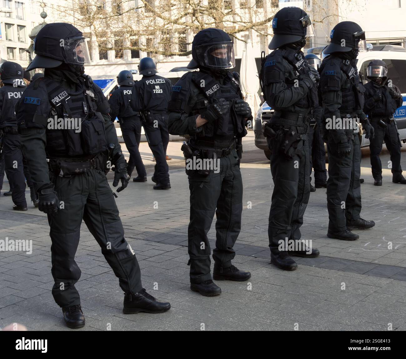 Hannover, 8. Februar 2025: Deutsche Polizeibeamte in schwarzer Kampfuniform und Schutzausrüstung stehen wachsam und sichern eine Demonstration Stockfoto