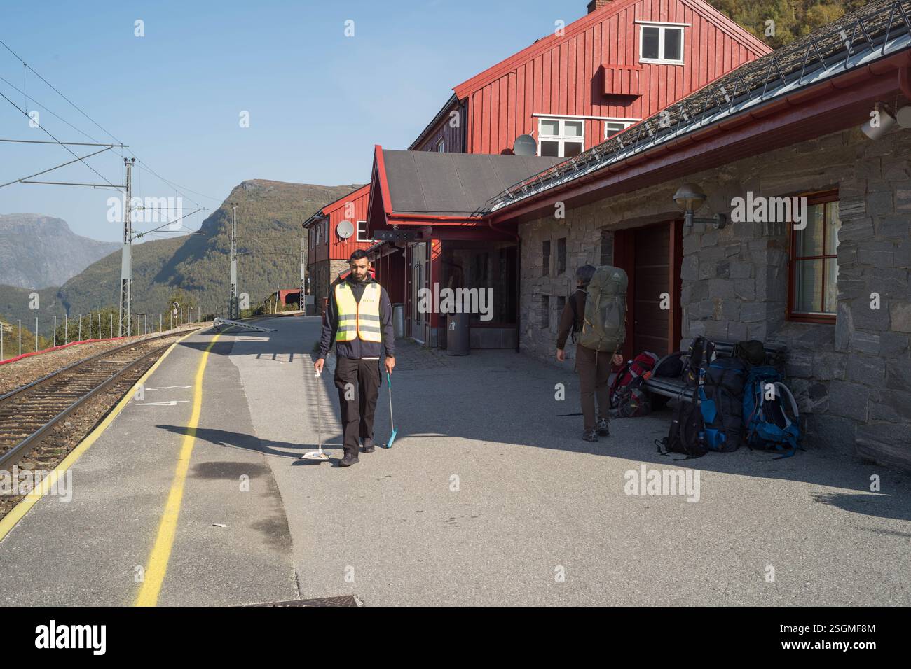 Ein Trianenwächter reinigt den Bahnsteig zwischen den Zügen Stockfoto
