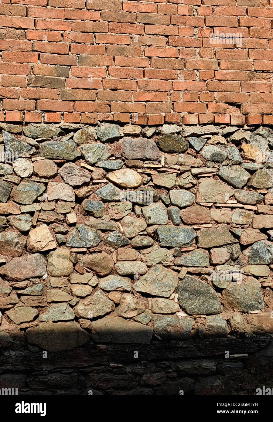 Strukturierte Harmonie – Ziegelwandmuster mit Steinen und Schatten Stockfoto