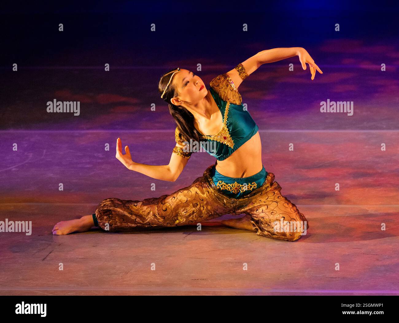 Tänzerin in bunten Kostümen tritt auf der Bühne mit dynamischer Pose und lebendiger Beleuchtung auf, The Nussknacker, Bainbridge Island, USA Stockfoto