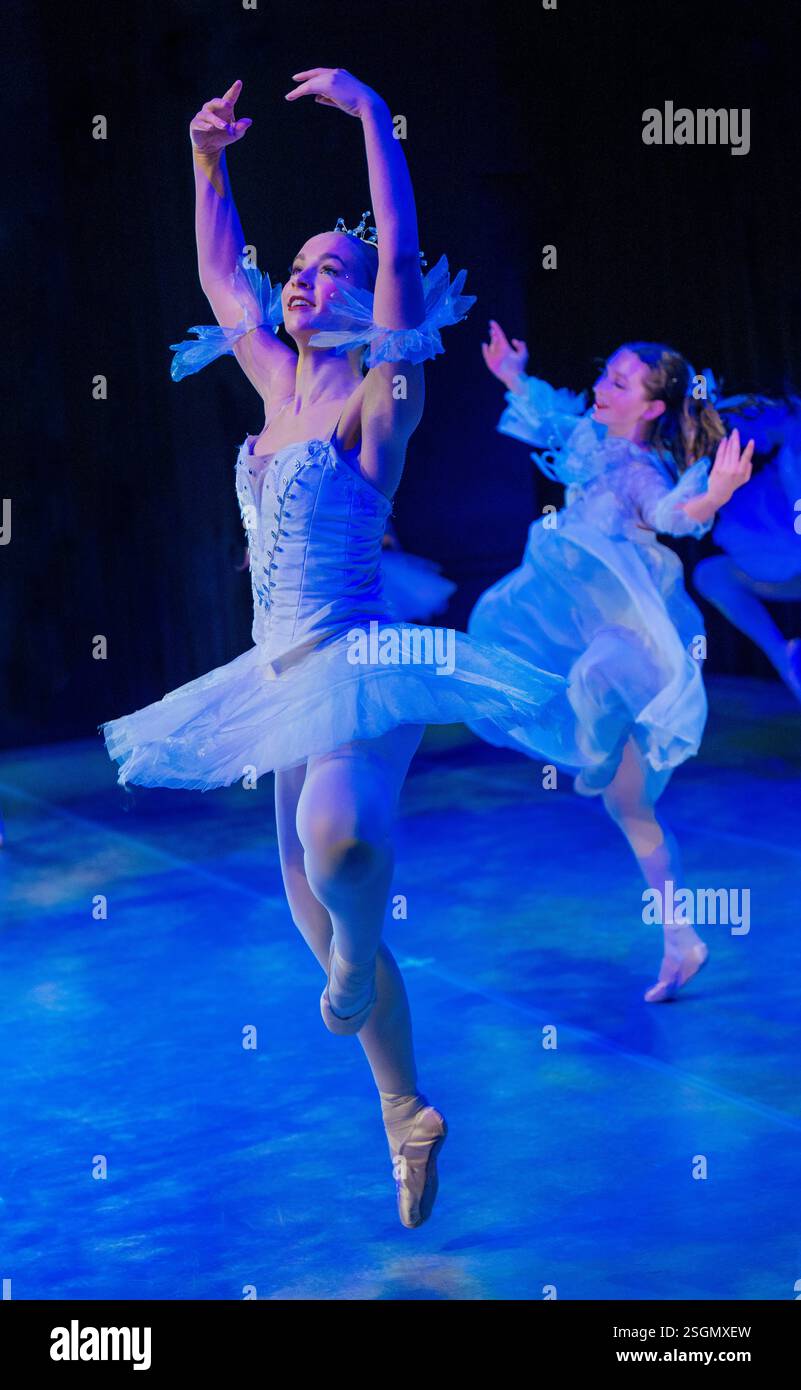 Ballerinas in weißem Tutus spielen einen anmutigen Tanz unter blauer Bühnenbeleuchtung. Der Nussknacker, Bainbridge Island, USA Stockfoto