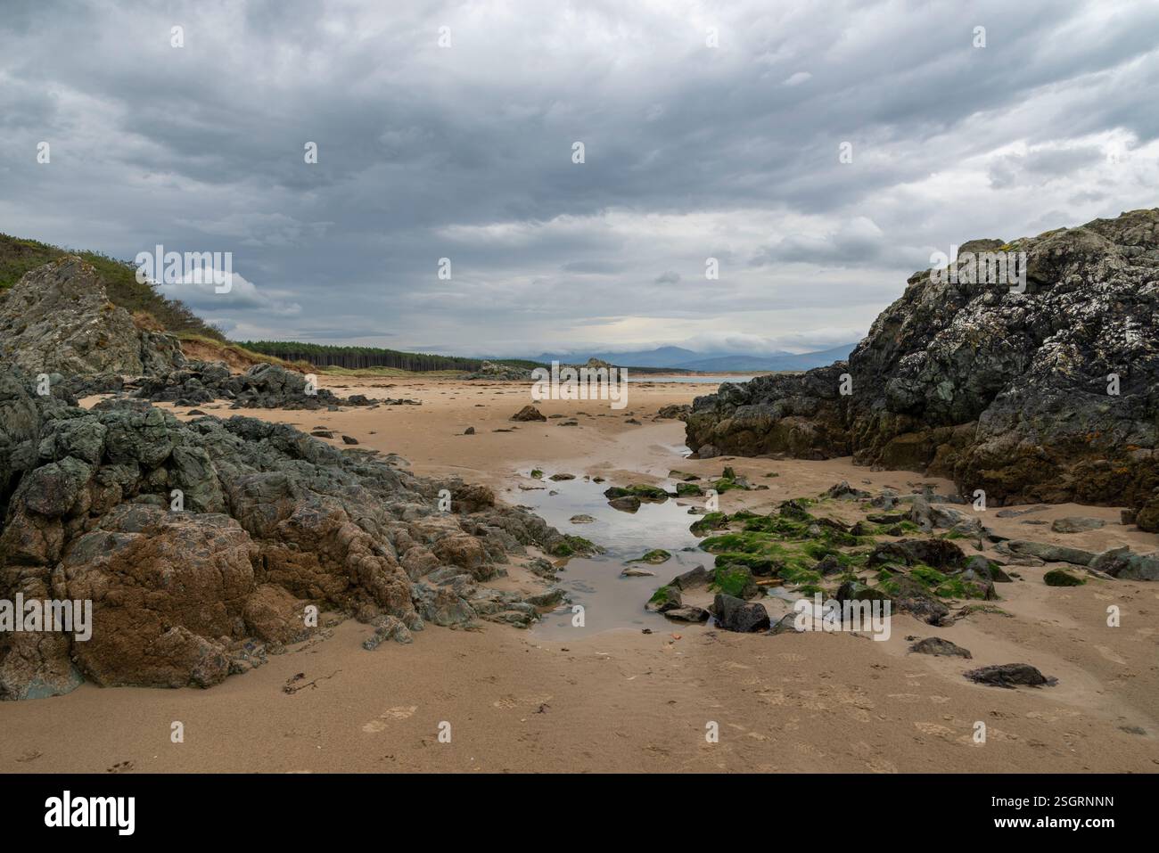 Felsen bilden sich am Newborough Beach in Anglesey, Nordwales. Stockfoto