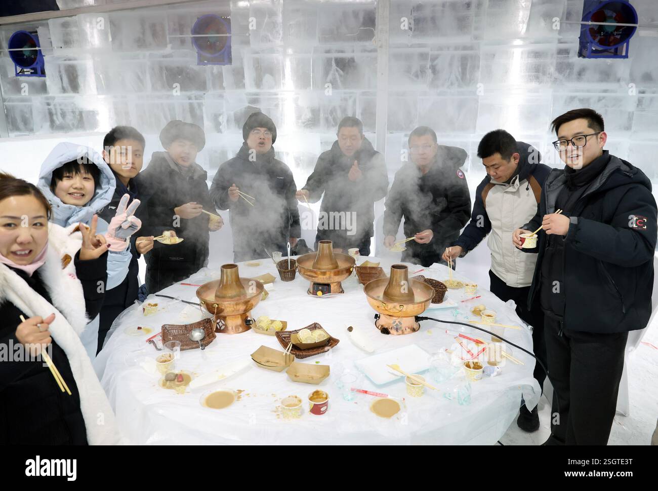 Harbin, Chinas Provinz Heilongjiang. Februar 2025. Touristen genießen Hot Pot auf einem Eistisch im Harbin Ice and Snow World Park in Harbin, nordöstlicher chinesischer Provinz Heilongjiang, 9. Februar 2025. Mit den 9. Asiatischen Winterspielen zieht Harbin zahlreiche einheimische und internationale Besucher an, die die Schönheit der Winterlandschaft genießen. Quelle: Hou Jun/Xinhua/Alamy Live News Stockfoto