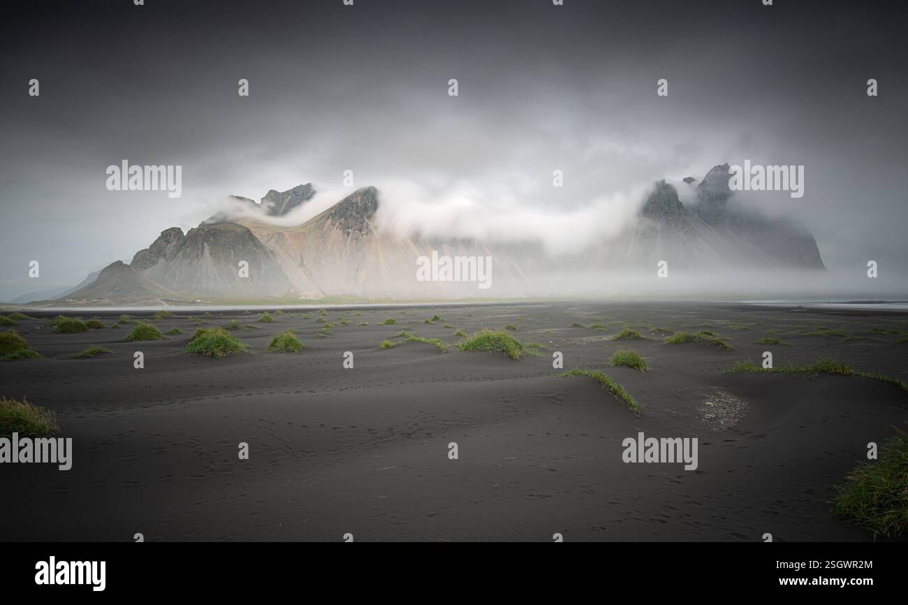 Atemberaubende isländische Landschaft mit Bergen, Wasserfällen und dramatischem Himmel. Die raue Schönheit der Natur im Land von Feuer und Eis Stockfoto