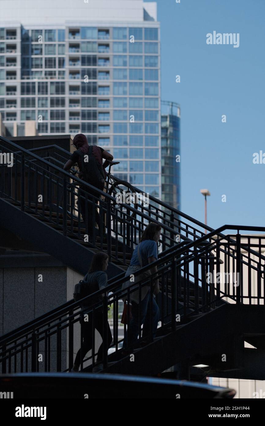Städtische Pendler auf Treppen vor modernem Stadtbild Stockfoto