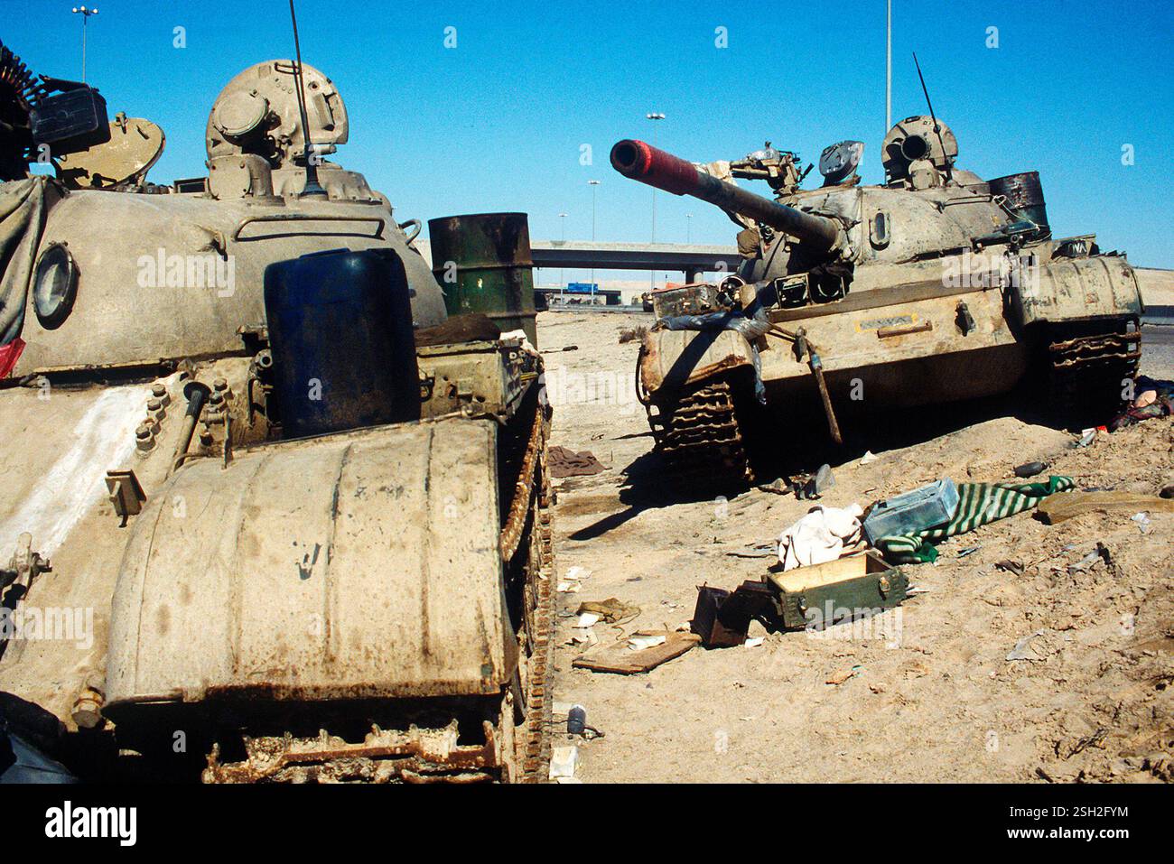 IN DER NÄHE VON KUWAIT, KUWAIT, liegen am 26. Februar 1991 zwei irakische Kampfpanzer T-55 auf dem Basra-Kuwait Highway in der Nähe von Kuwait City, Kuwait After Stockfoto