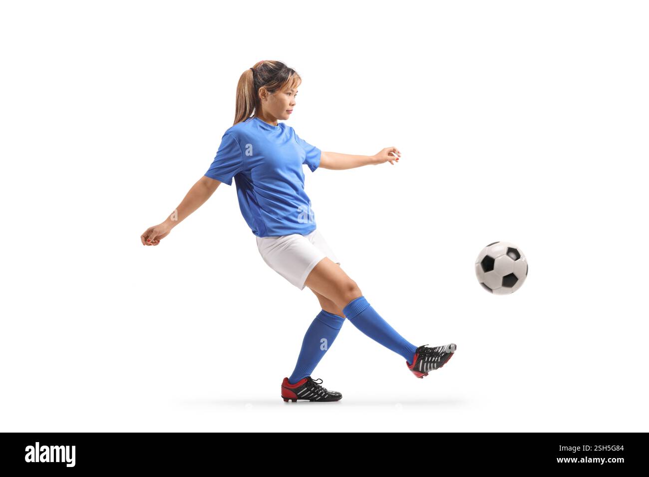 Asiatische Frau tritt einen Fußball isoliert auf weißem Hintergrund Stockfoto