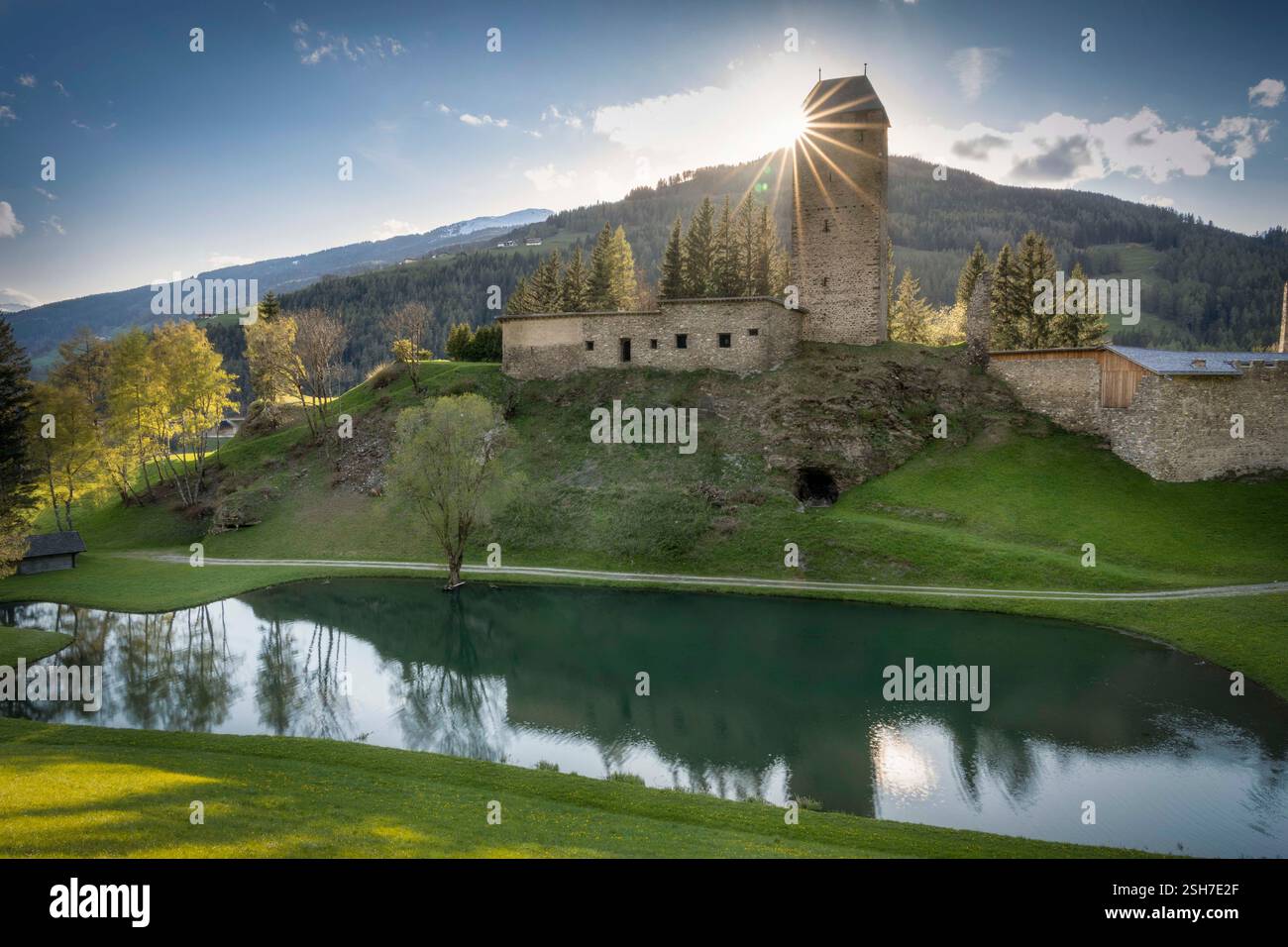 Schloss in Südtirol mit Sonnenstern hinter dem Burgturm Stockfoto