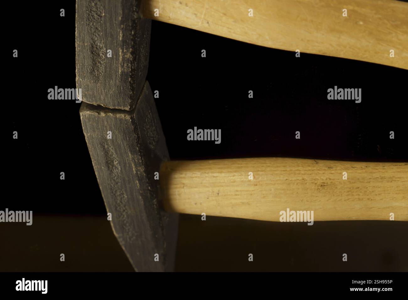 Nahaufnahme eines Hammers, der in einem Spiegel reflektiert wird, der auf einem schwarzen Hintergrund mit Kopierraum isoliert ist Stockfoto