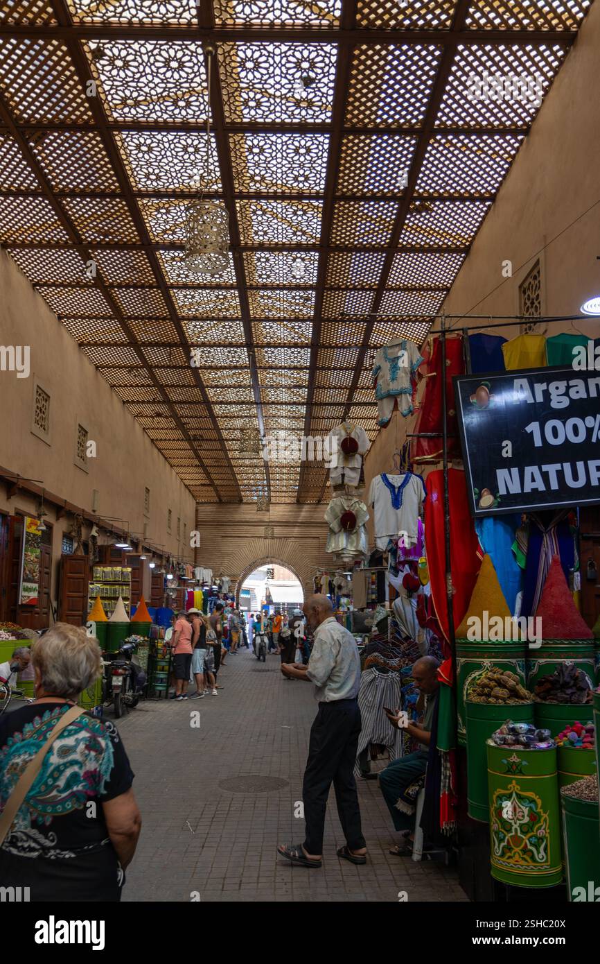 Souk of Marrakesch Medina Street Life, Touristen und Einheimische spazieren durch den Souk der Gewürze, Kunsthandwerk, Teppiche, traditionelle Kleidung. Stockfoto