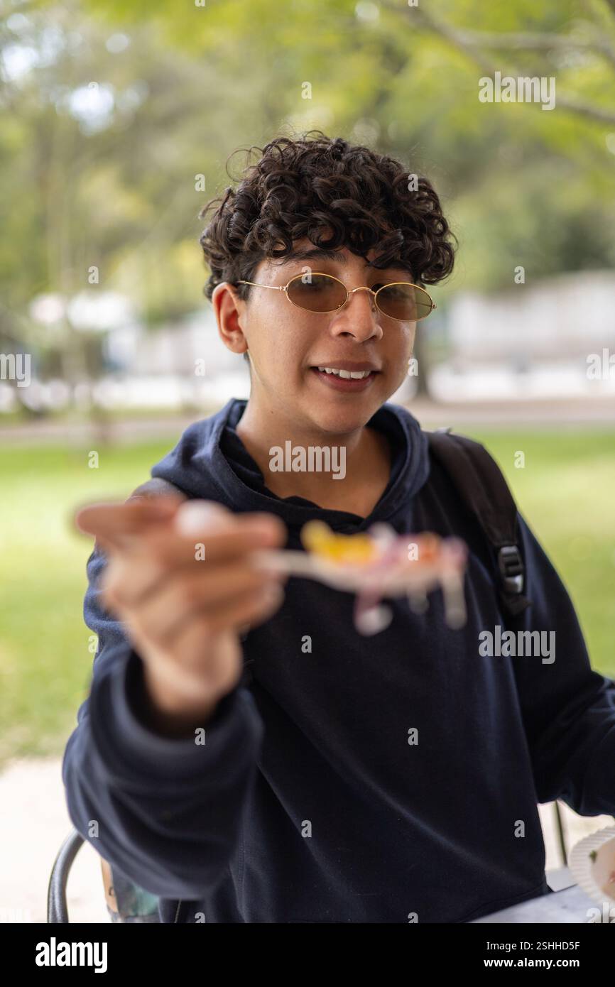 Sie bieten einen Löffel Essen, das Sie mit anderen teilen können, perfekt für Themen wie Teilen, Esskultur, Großzügigkeit und geselliges Essen. Stockfoto