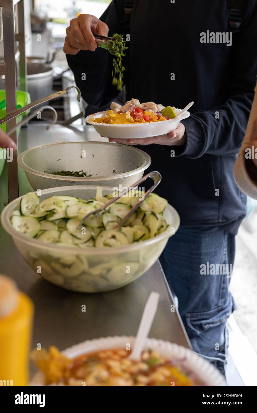 Zubereitung eines frischen Tellers Cevichocho mit Chochos, Gemüse und Gewürzen, perfekt für Themen wie ecuadorianische Küche, traditionelle Gerichte und s Stockfoto