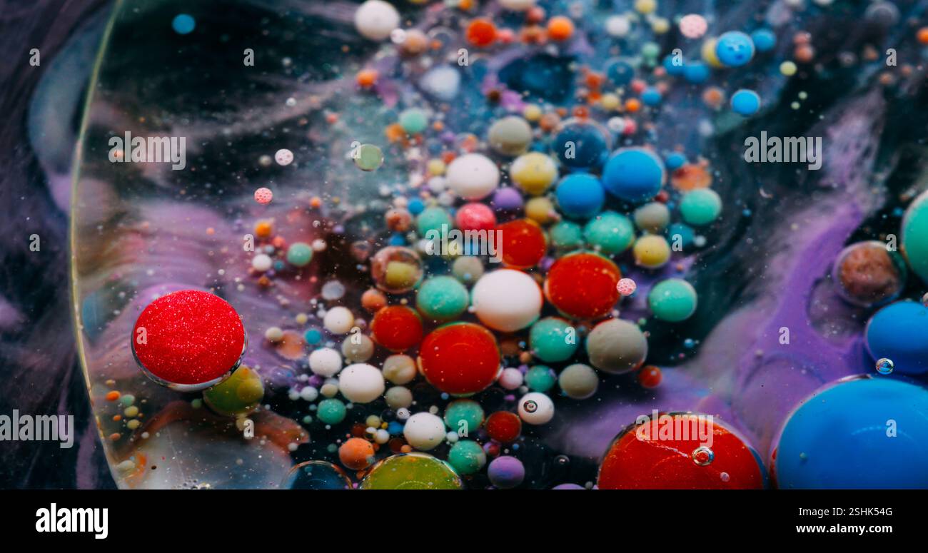 Luftblasen verschütten. Tintenfluss. Ölfarbtropfen lösen sich in Wasser auf. Farbenfroher Acrylpigmentschaum schwimmender abstrakter Kunsthintergrund. Stockfoto