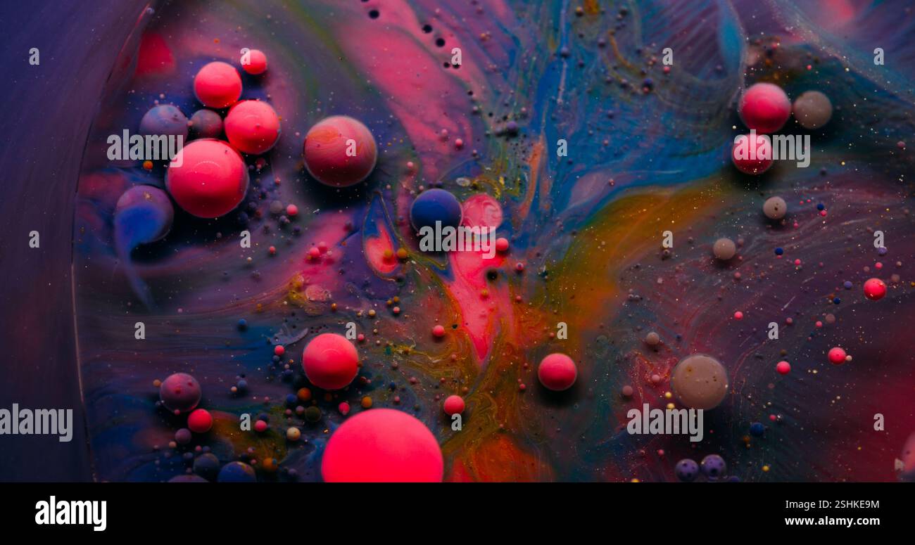 Luftblasen verschütten. Tinte löst sich auf. Ölfarbe Tropfen Explosion auf dunkler Oberfläche. Rosa violette Pigmentstaub verbreitet abstrakten Kunsthintergrund. Stockfoto