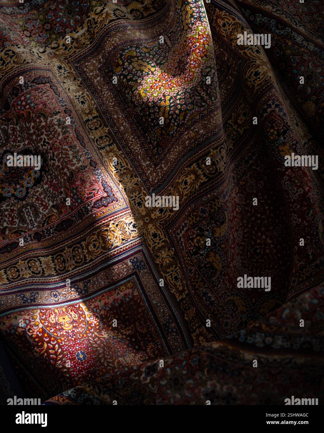 Nahaufnahme eines traditionellen persischen Teppichs mit detaillierten Blumenmotiven in Rot, Blau und Gold Stockfoto