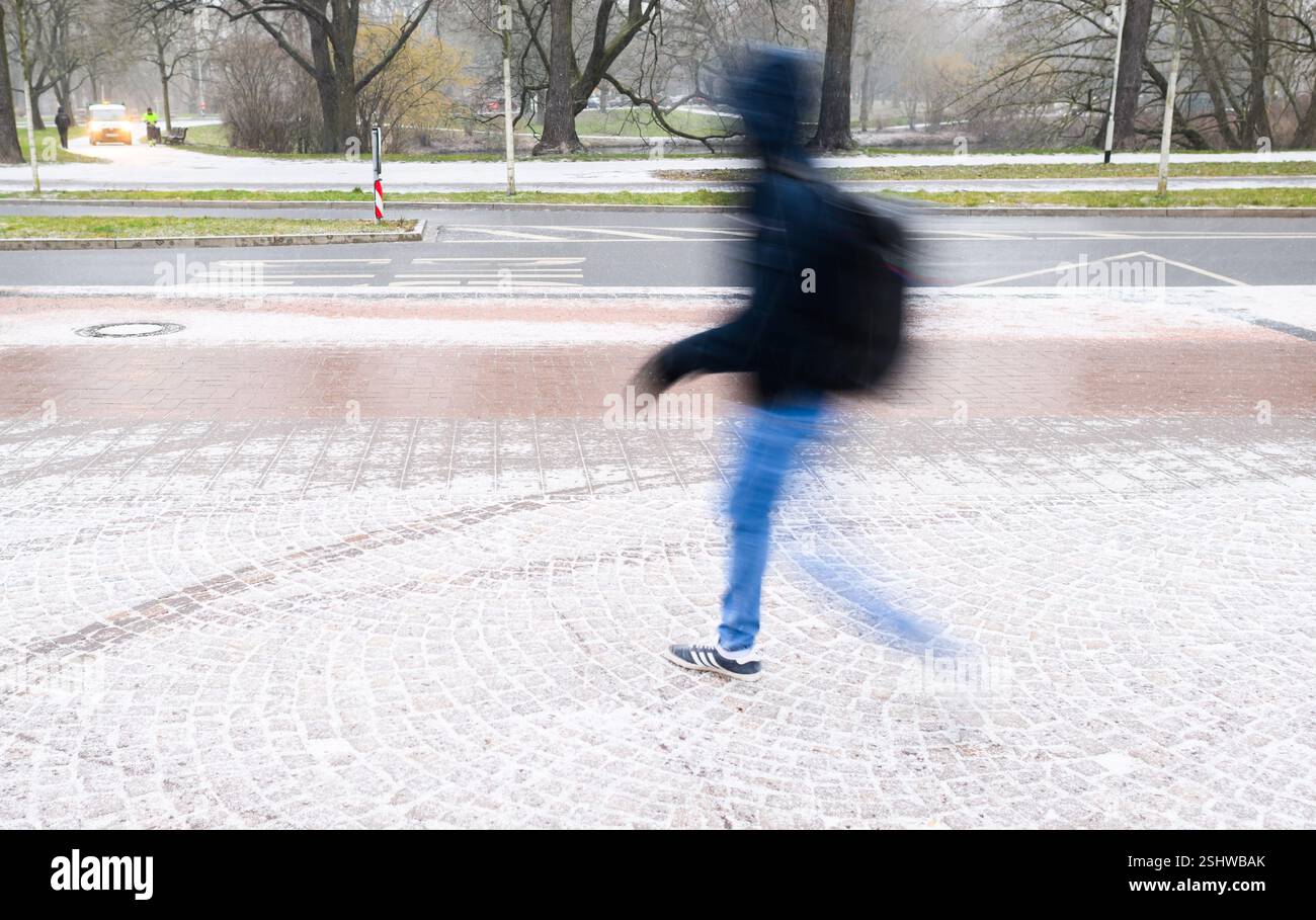 Hannover, Deutschland. Februar 2025. Ein Mann läuft auf einem schneebedeckten Gehweg. Quelle: Julian Stratenschulte/dpa/Alamy Live News Stockfoto