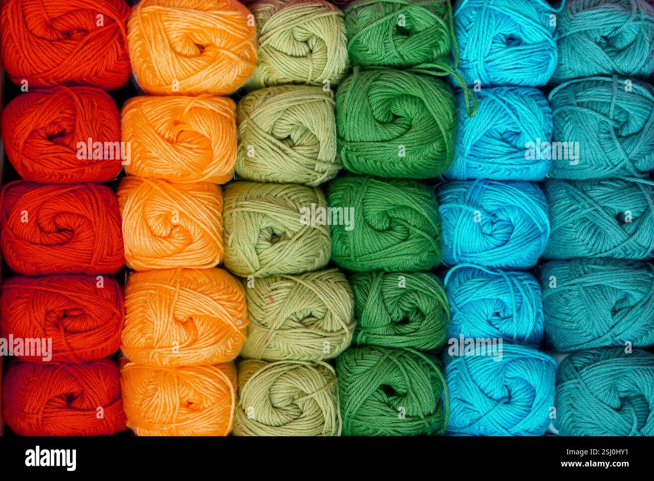 Hintergrund von bunten Kugeln aus Wollfäden zum Stricken, lebendige Farben Muster, Material für handgefertigte Artikel, Handstricken und Handarbeiten Stockfoto