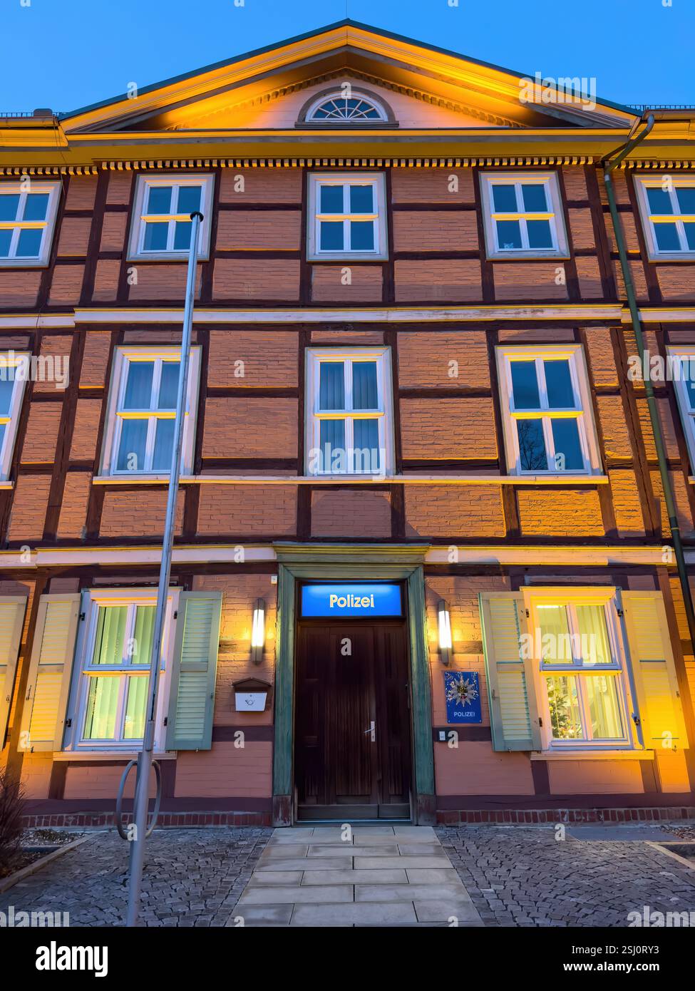 Polizeiwache in Wernigerode, Sachsen-Anhalt. Historisches Fachwerkgebäude im Harz, beleuchtet nach Sonnenuntergang. Stockfoto