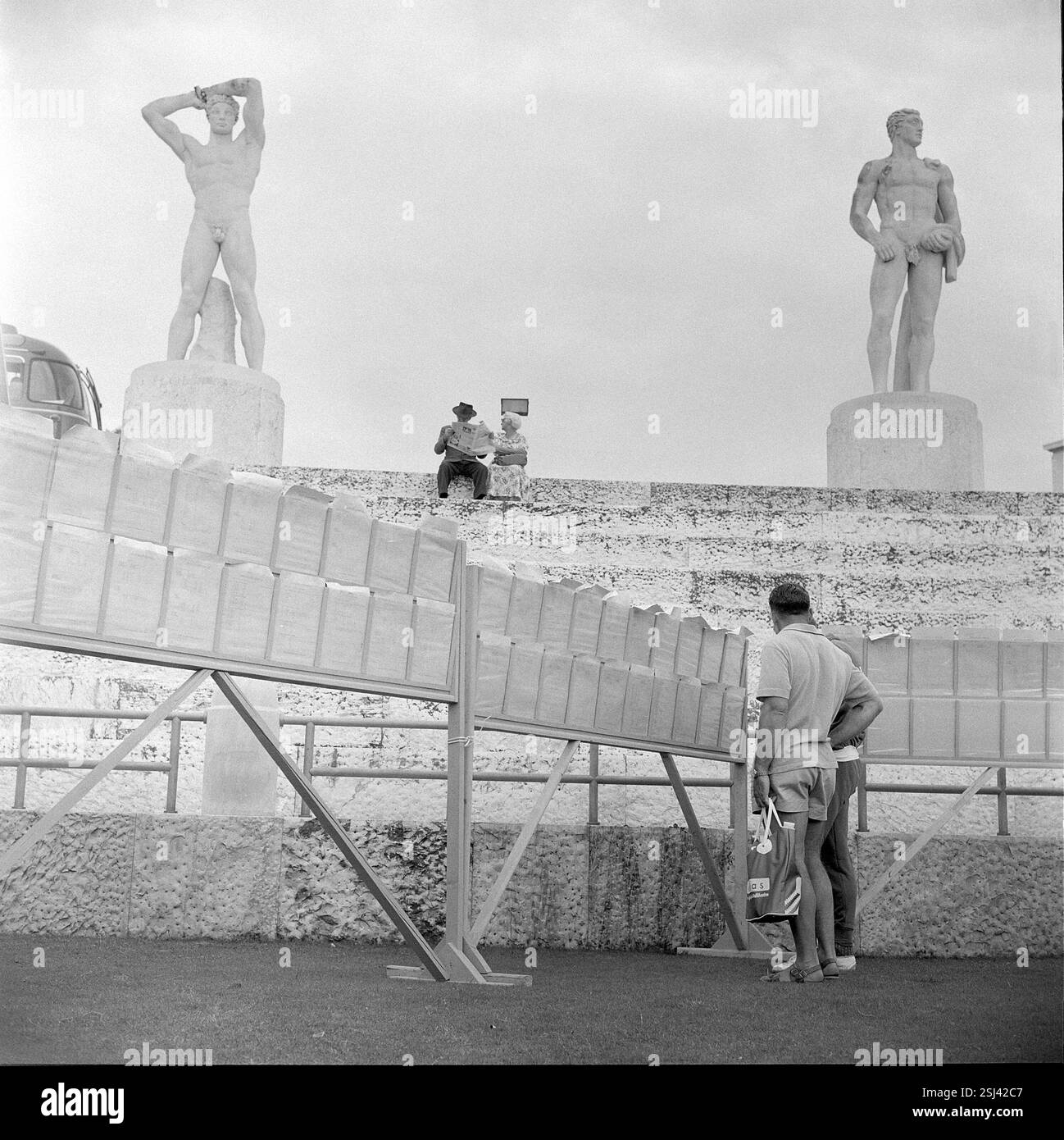 --- Rom 1960: Zeitung- und Tageprogramm-Lesen im Olympiastadion#Rome 1960: Zeitung und Tagesprogramm im olympiastadion Stockfoto