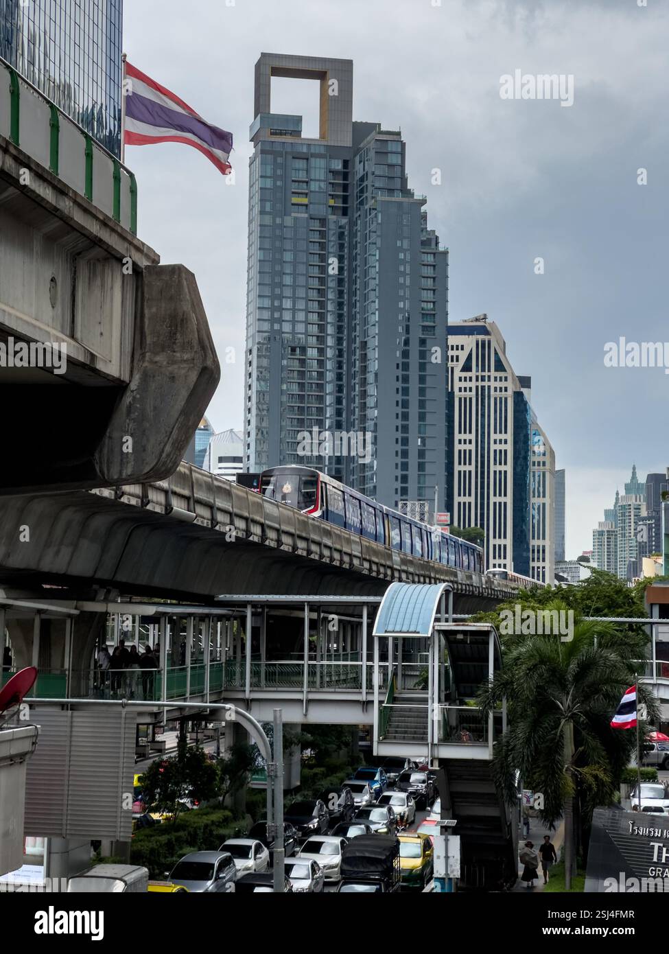 Eine Tagesszene auf der Sukhumvit Road in Bangkok fängt das Wesen der Stadtentwicklung und des Verkehrs ein. Das Bild zeigt den BTS Skytrain im Moti Stockfoto
