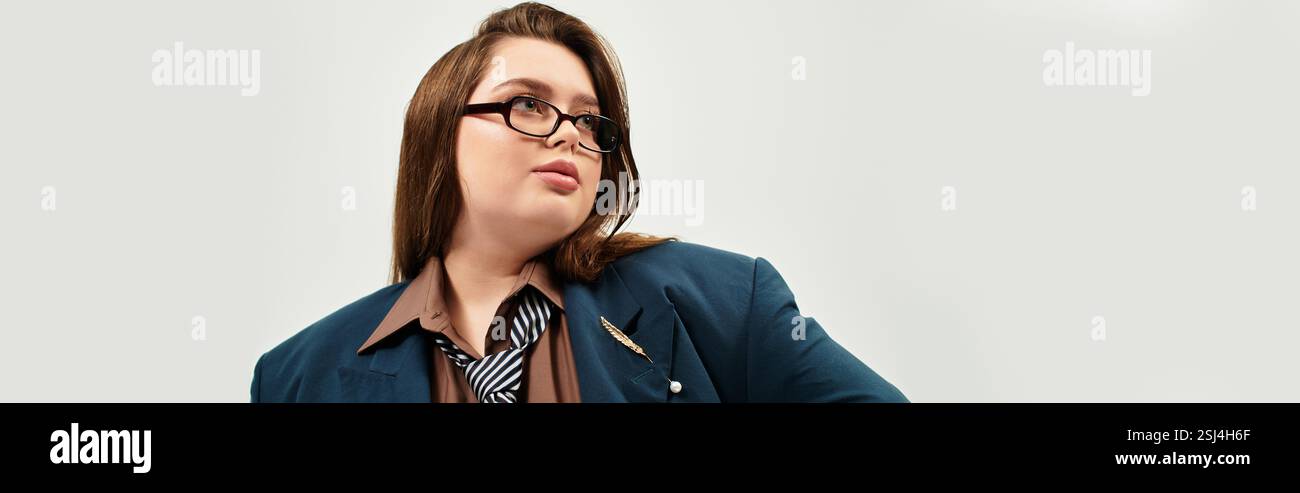 Eine Frau in Übergröße mit Brille zeigt ihren einzigartigen Stil, während sie drinnen eine selbstbewusste Pose zeigt. Stockfoto