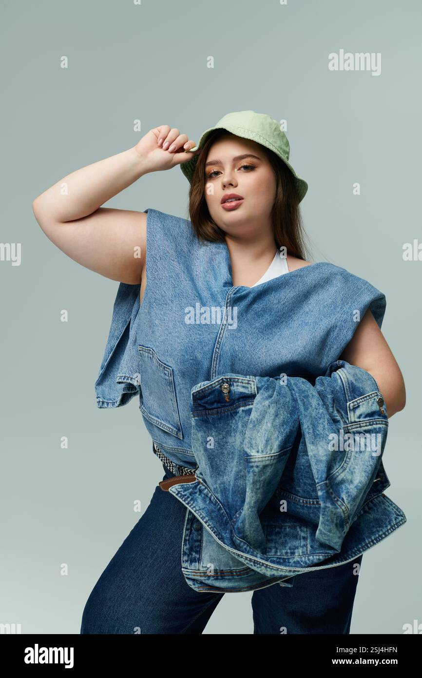 Eine junge Frau in Übergröße drückt ihre Persönlichkeit durch Denim und Accessoires aus. Stockfoto